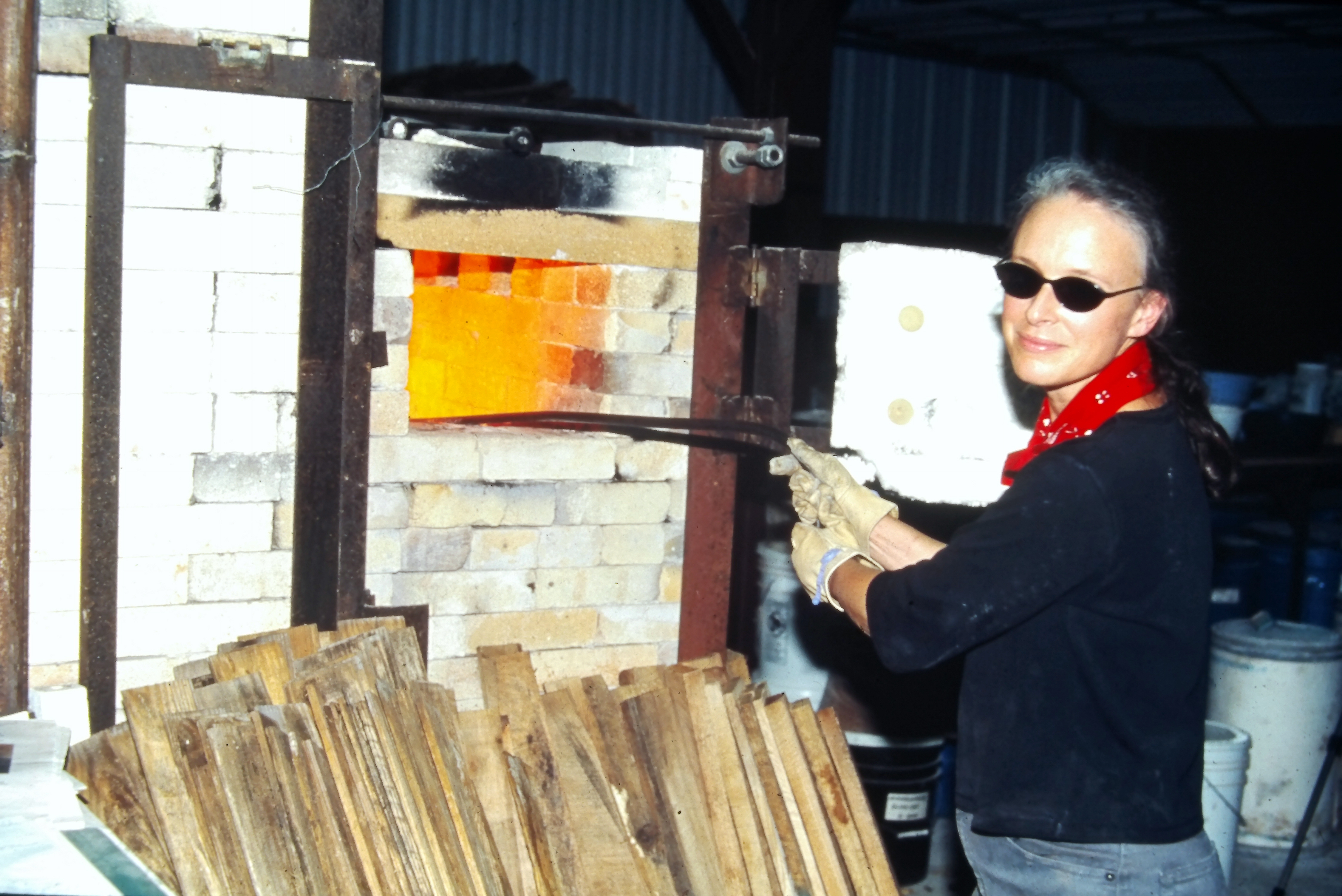 Daphne Roehr Hatcher feeding the upper firebox at Pine Mills Pottery, 1993.