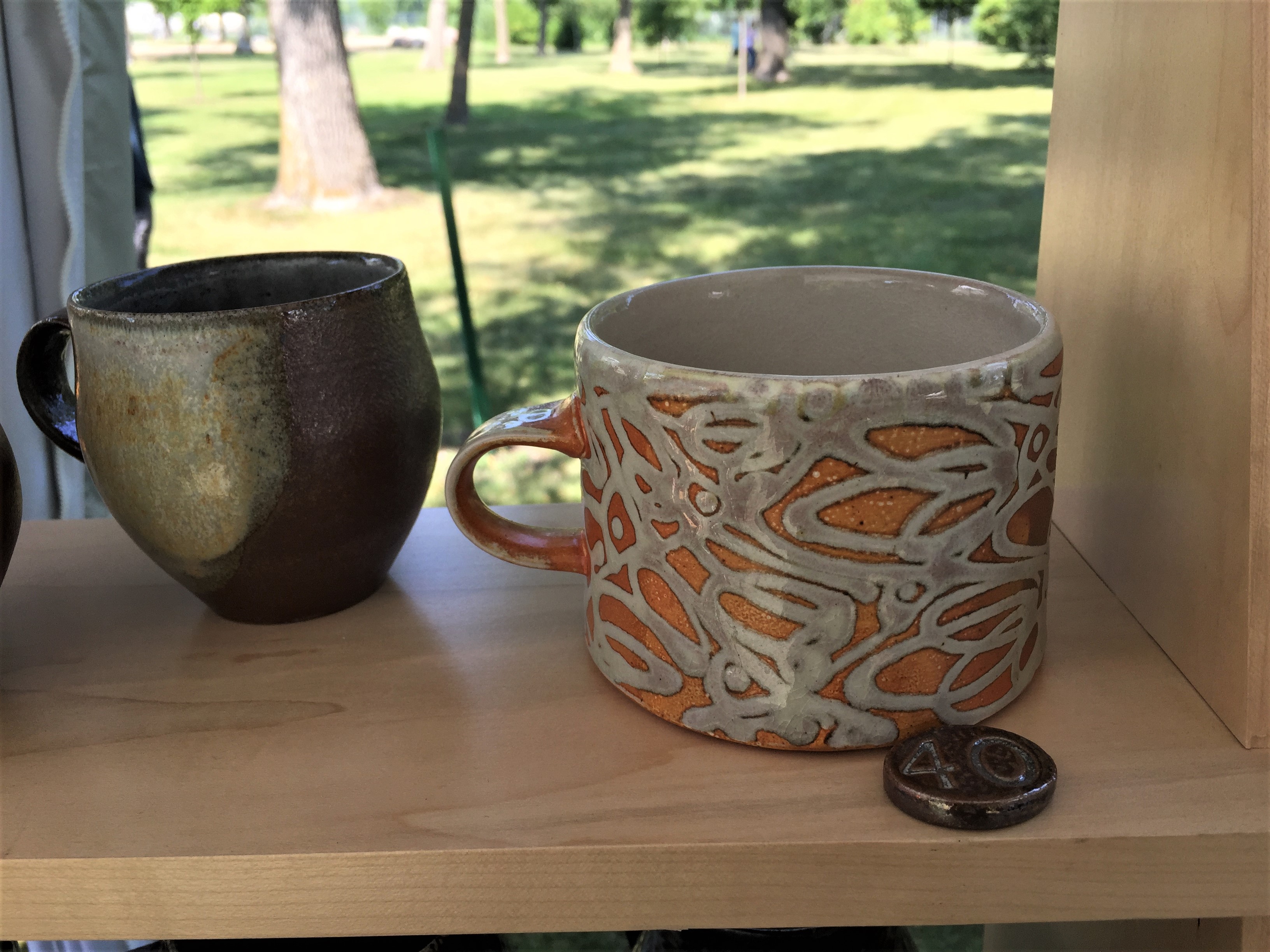 Mugs ready for new homes and attention to detail shows up in soda fired pricing buttons. Photo credit: Clarice Allgood