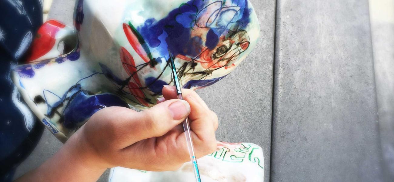 Cambric applies her luster overglaze to her footed bowls. Photo by artist, 2015.