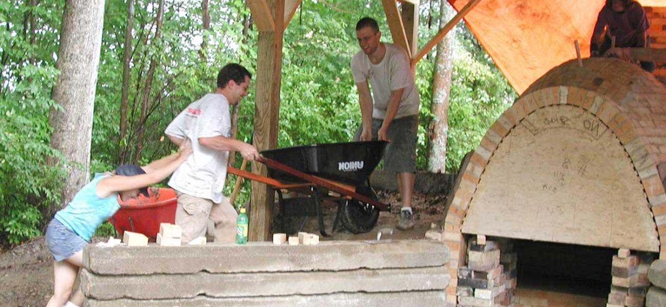 Simon Levin is assisted up the side berm during the construction of the anagama kiln at Corning Community College, Corning, New York, in 2003. Photograph by Dr. Robert Tichane. 