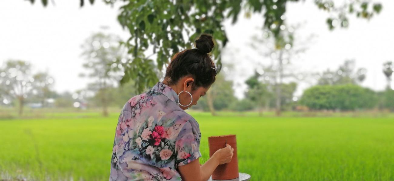 Sa Wanphet sits beside a rice paddy and experiments with surface texture on clay vase Sukhothai, Thailand, 2017. All photographs courtesy of Sa Wanphet.