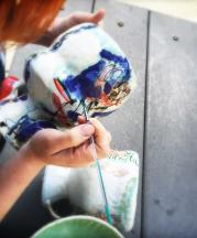 Cambric applies her luster overglaze to her footed bowls. Photo by artist, 2015.