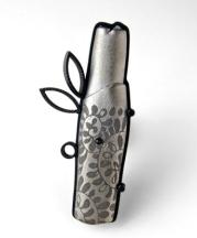 Paul W. Leathers, JDZ (Silver Fern) Fragment Brooch, 2013. Oxidized sterling silver with titanium (PVD) coated porcelain, underglaze transfers, 2.75 x 1.25 x 0.5 in. Photograph by the author.